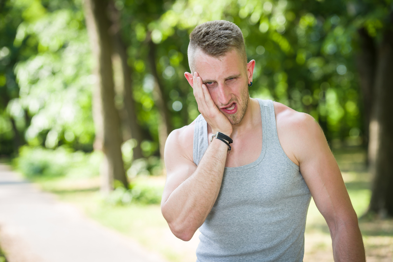 sport man toothache in a park